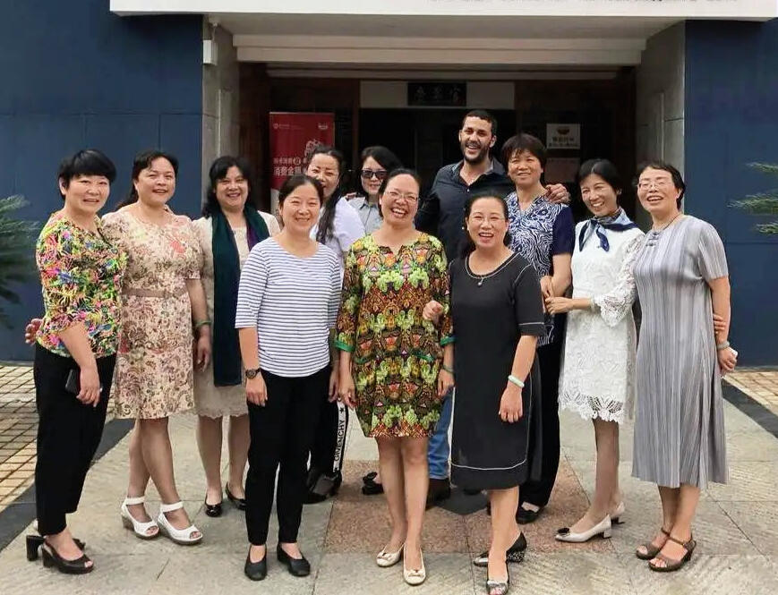 Delivering Real Solutions for Chinese Tour Groups in Morocco Reda Akrime with 10 Chinese tourists dressed elegantly in front of a Moroccan restaurant, taking a group photo
